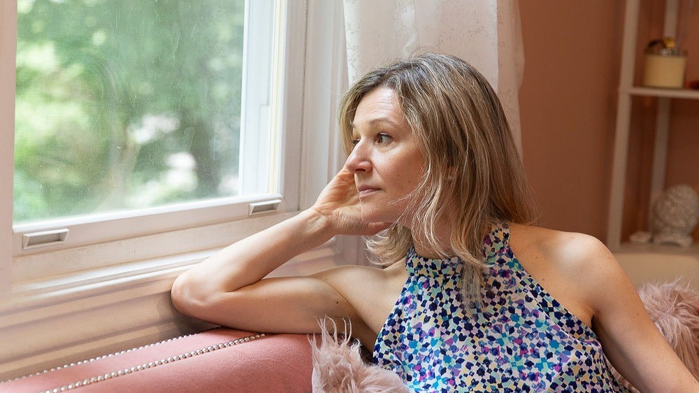 Dasha looking out a window, lost in thought